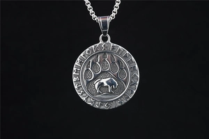 Detail view of vintage Viking bear paw pendant with Nordic runes on a steel box chain