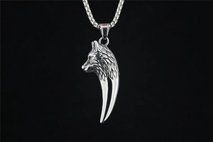 Detailed macro view of a vintage silver wolf head pendant with sharp fang design detail