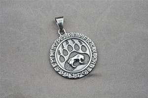 Macro detail of Viking bear paw pendant with rune engraving and steel mesh texture