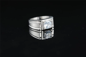 Macro shot of men's wide silver polished stainless steel ring with a large center zircon
