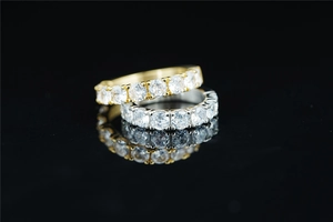 Macro shot of gold and silver moissanite eternity rings with claw setting on black background