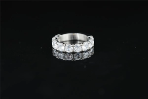 Macro view of a classic silver titanium ring with row-set Moissanite on black background