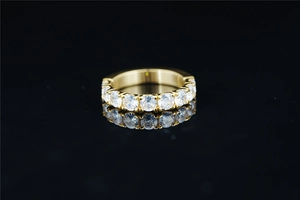 Macro shot of gold-plated eternity ring with brilliant round-cut moissanite stones