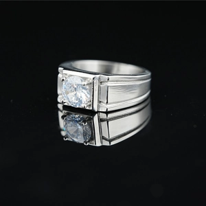 Mens silver stainless steel ring with single solitaire moissanite diamond on black surface