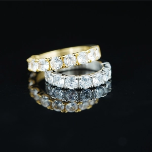 Classic gold and silver eternity rings with round cut moissanite on black mirror surface