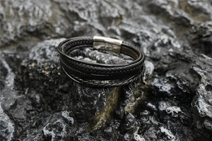 Macro detail of multilayer braided black leather bracelet with magnetic metal clasp