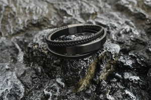 Detail of multi-layer leather braided bracelet with brushed steel magnetic clasp on rock