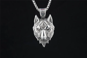 Macro detail of silver wolf head pendant with Nordic runes and textured metal finish
