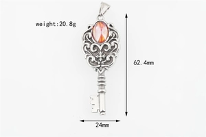 Macro view of vintage silver key pendant with red gemstone and size dimensions