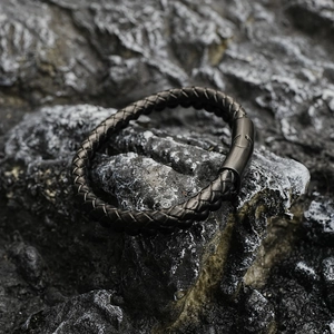 Bracelet double couche en cuir tressé noir avec fermoir magnétique sur socle de roche