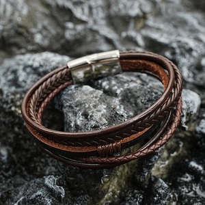Handmade multilayer leather braided bracelet with magnetic clasp on dark rock background