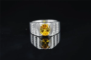 Vista macro de una gema amarilla ovalada en un anillo de plata con tres filas de diamantes