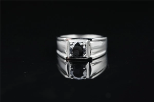 Primer plano de un anillo de plata pulida para hombre con una gran moissanita negra