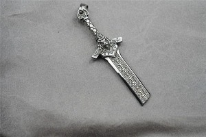 Macro shot of gothic sword pendant with lion head relief and engraved runes detail