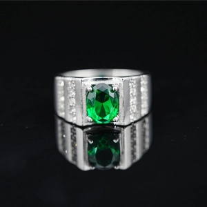 Anillo clásico de titanio con gran gema verde ovalada y banda de plata con diamantes