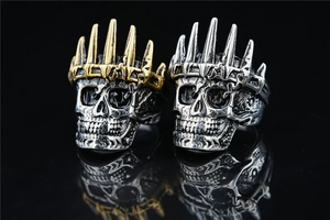 Detailed close-up of retro gothic skull crown rings in silver and gold steel finish