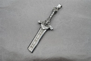 Close-up of vintage sword pendant featuring intricate warrior carvings and Nordic runes