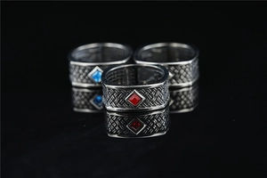 Macro shot of retro woven rings with inlaid square-cut red and blue gemstones