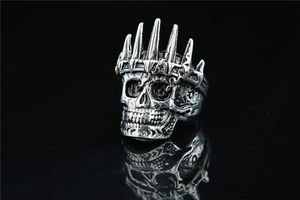 Macro shot of vintage steel skull ring with crown showing oxidized gothic textures