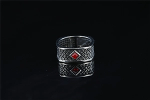 Detailed macro view of retro woven texture and square red gemstone on the vintage ring