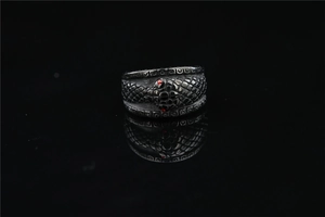 Detail of vintage silver snake ring featuring red gemstone eyes and scale textures