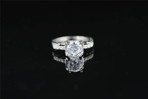 Macro-opname van een briljante moissanite solitaire ring met pavé-stenen op zwarte spiegel