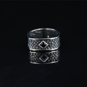 Vintage style stainless steel ring with black diamond gemstone and woven pattern on black background