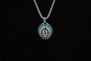 Détail d'un pendentif de chef indien avec incrustations de turquoise et accents rouges