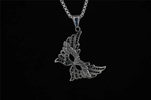 Macro detail of gothic silver wing mask pendant with black zircons on a link chain