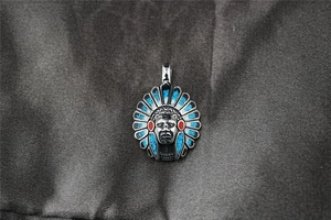 Détail du pendentif chef indien en acier titane vintage avec incrustations turquoise