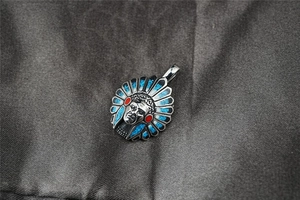 Détail du pendentif chef indien avec incrustations turquoises et finition acier vintage