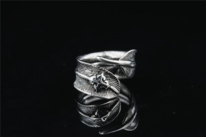 Macro shot of vintage silver feather ring with cross relief and oxidized finish texture