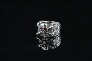 Close-up of punk skull ring with red zircon eyes and vintage silver bone texture