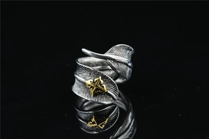 Detail of vintage feather ring with gold cross emblem and intricate carved texture