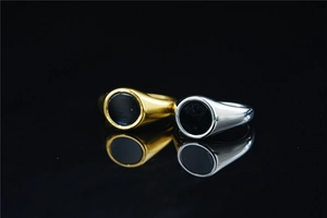 Detailed macro view of gold and silver signet rings with black enamel inlay surfaces