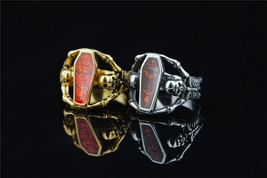 Detailed macro view of Gothic coffin rings with skull carvings in gold and silver