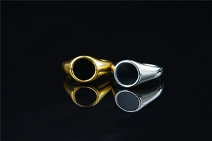 Macro shot of gold and silver signet rings with black enamel inlay and mirror reflections