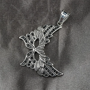 Vintage gothic wing pendant necklace with black stones on grey silk background