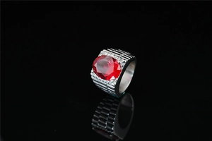 Macro detail of men's titanium ring featuring large red zircon and ribbed metal band