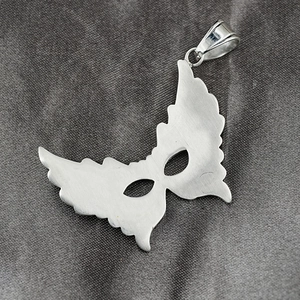 Polished silver butterfly wing mask pendant necklace for men and women on gray fabric