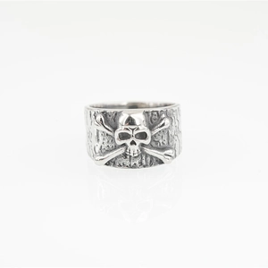 Vintage silver skull and crossbones ring with punk rock textured finish on white background