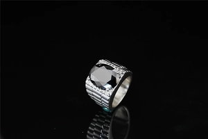 Detailed close-up of a men's titanium steel ring featuring a large oval black gemstone