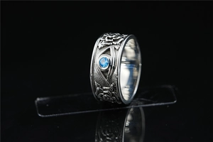 Detailed macro view of vintage titanium steel ring with rose relief and blue gemstone