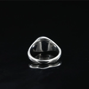 Minimalist silver signet ring with a high-polished mirror finish on a black background
