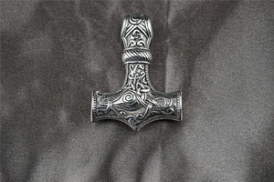 Gros plan détaillé du pendentif marteau de Thor argenté avec gravures celtiques