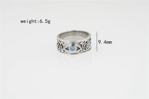 Macro detail of vintage steel ring showing Eye of Horus blue stone and floral reliefs