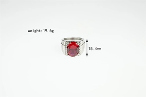 Detail of silver titanium steel ring with red oval gemstone and textured band edges