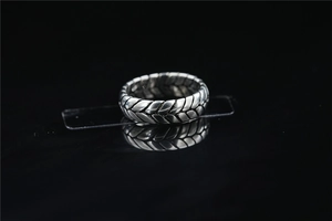 Macro view of tire-patterned textured ring band with vintage woven silver details