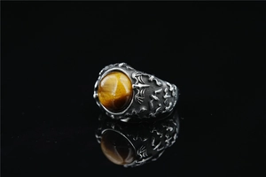 Macro detail of gothic bat ring with tiger eye stone on polished vintage silver band