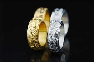 Detailed view of titanium steel rings featuring Eye of Horus embossed patterns in gold and silver